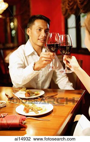 Couple toasting with wine at restaurant View Large Photo Image Stock Image - Couple toasting with wine at restaurant. Fotosearch
