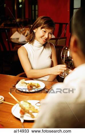 Couple toasting with wine at restaurant, over the shoulder view View Large Photo Image Stock Image - Couple toasting with wine at restaurant, over the shoulder view. Fotosearch