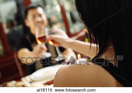 Couple toasting with wine glasses, over the shoulder view, selective focus View Large Photo Image Stock Photography - Couple toasting with wine glasses, over the shoulder view, selective focus. Fotosearch
