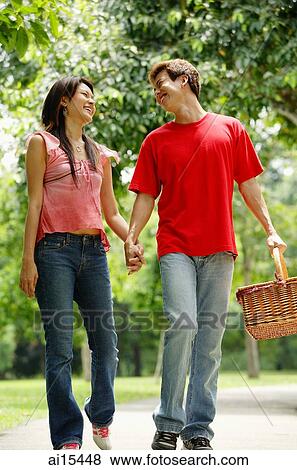 Couple walking in park, man carrying picnic basket View Large Photo Image Stock Photo - Couple walking in park, man carrying picnic basket. Fotosearch