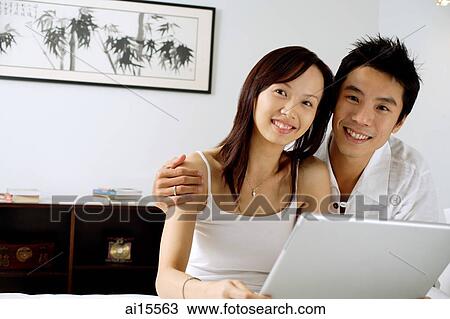 Couple with laptop, smiling at camera View Large Photo Image Stock Image - Couple with laptop, smiling at camera. Fotosearch