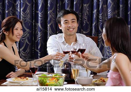 Couples having dinner at home, toasting with drinks View Large Photo Image Picture - Couples having dinner at home, toasting with drinks. Fotosearch