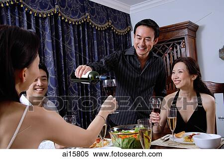 Couples having dinner party at home, man pouring wine for woman View Large Photo Image Stock Photography - Couples having dinner party at home, man pouring wine for woman. Fotosearch
