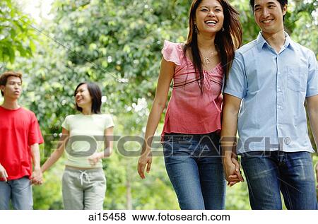 Couples holding hands and walking in park View Large Photo Image Stock Photo - Couples holding hands and walking in park. Fotosearch