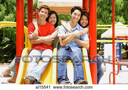 Couples in playground, smiling at camera, portrait View Large Photo Image Stock Image - Couples in playground, smiling at camera, portrait. Fotosearch