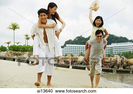 Couples on beach, men carrying women on their backs View Large Photo Image Stock Image - Couples on beach, men carrying women on their backs. Fotosearch