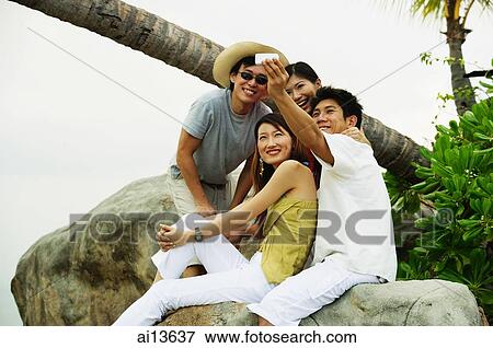 Couples sitting on rock, taking a picture View Large Photo Image Stock Photo - Couples sitting on rock, taking a picture. Fotosearch