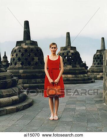 Stock Image - Eurasian model holding handbag at Borobudur temple. Fotosearch