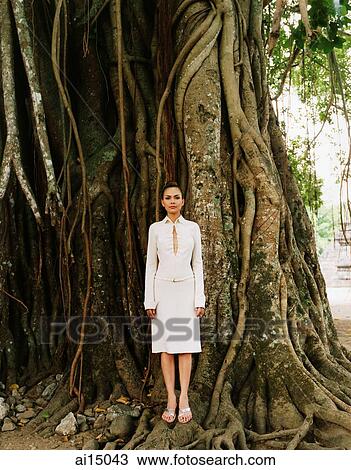 Stock Image - Eurasian model standing in front of Banyan tree. Fotosearch