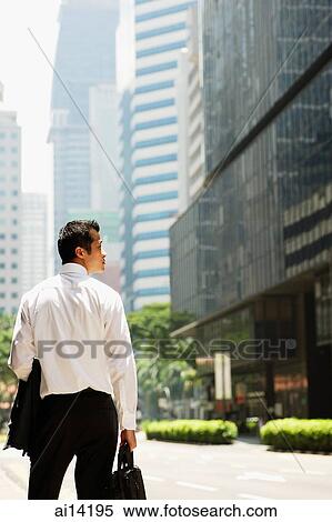 Executive carrying briefcase and jacket, looking to the side, rearview View Large Photo Image Stock Photography - Executive carrying briefcase and jacket, looking to the side, rearview. Fotosearch