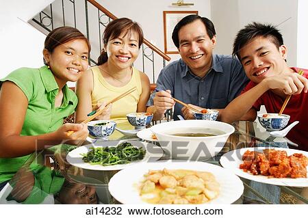 Family at home, looking at camera, food on the table in front of them View Large Photo Image Stock Image - Family at home, looking at camera, food on the table in front of them. Fotosearch