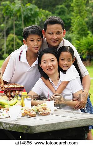 Family at picnic table, looking at camera View Large Photo Image Stock Photograph - Family at picnic table, looking at camera. Fotosearch