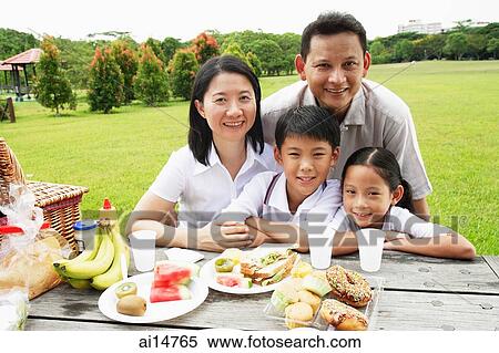 Family at picnic table, looking at camera, smiling View Large Photo Image Stock Photography - Family at picnic table, looking at camera, smiling. Fotosearch
