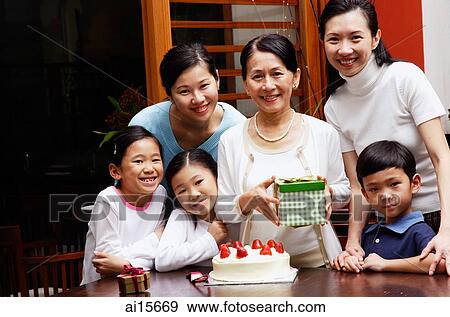Family celebrating birthday, looking at camera View Large Photo Image Stock Photo - Family celebrating birthday, looking at camera. Fotosearch