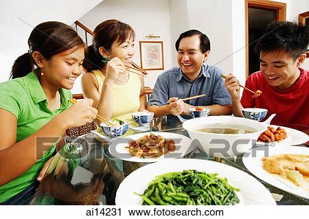 Stock Image - Family eating dinner at home. Fotosearch