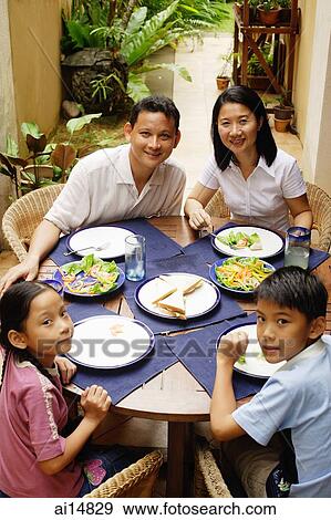 Family having a meal outdoors, looking at camera View Large Photo Image Stock Photo - Family having a meal outdoors, looking at camera. Fotosearch