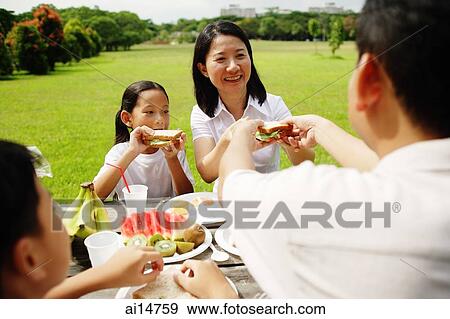 Stock Photo - Family having a picnic in park. Fotosearch