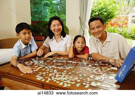 Family in living room, jigsaw puzzle on table View Large Photo Image Stock Image - Family in living room, jigsaw puzzle on table. Fotosearch