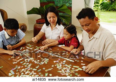 Family in living room working on jigsaw puzzle together View Large Photo Image Stock Photography - Family in living room working on jigsaw puzzle together. Fotosearch