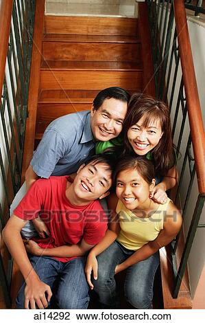Family of four sitting on stairs, looking at camera, portrait View Large Photo Image Stock Image - Family of four sitting on stairs, looking at camera, portrait. Fotosearch