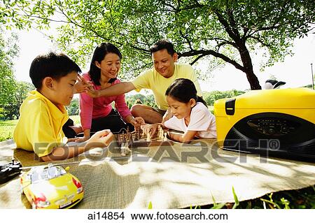 Family playing chess, sitting on picnic mat View Large Photo Image Picture - Family playing chess, sitting on picnic mat. Fotosearch