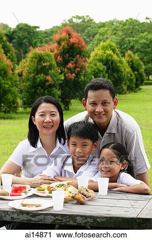 Family seated at picnic table, portrait View Large Photo Image Stock Image - Family seated at picnic table, portrait. Fotosearch