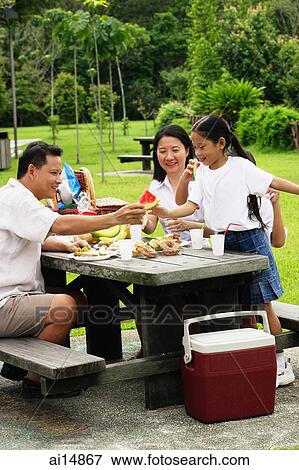 Family seated at picnic table View Large Photo Image Stock Photo - Family seated at picnic table. Fotosearch