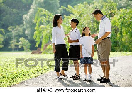 Family standing and talking in park View Large Photo Image Stock Photo - Family standing and talking in park. Fotosearch