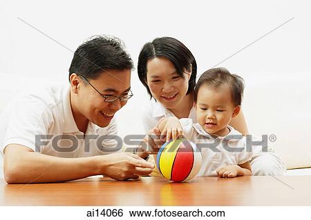 Family with one child, daughter playing with ball View Large Photo Image Stock Photograph - Family with one child, daughter playing with ball. Fotosearch