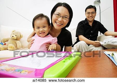 Family with one child in living room, looking at camera, portrait View Large Photo Image Stock Photography - Family with one child in living room, looking at camera, portrait. Fotosearch
