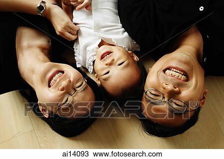 Family with one child lying on floor looking at camera View Large Photo Image Stock Image - Family with one child lying on floor looking at camera. Fotosearch
