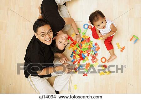 Family with one child sitting on floor looking at camera View Large Photo Image Picture - Family with one child sitting on floor looking at camera. Fotosearch