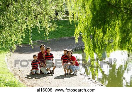 Family with three boys outdoors in park, smiling at camera View Large Photo Image Stock Photo - Family with three boys outdoors in park, smiling at camera. Fotosearch