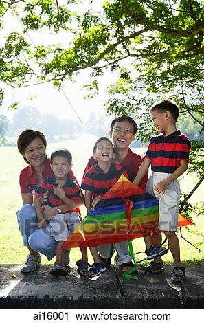Stock Image - Family with three boys, outdoors, smiling at camera. Fotosearch