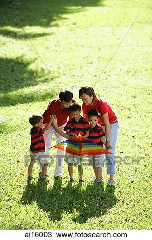 Stock Image - Family with three boys, outdoors with kite. Fotosearch