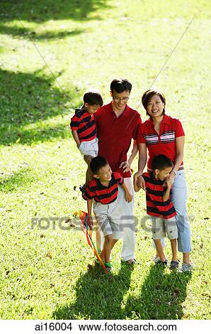 Family with three boys, standing on field, looking at camera View Large Photo Image Picture - Family with three boys, standing on field, looking at camera. Fotosearch