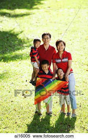 Stock Photography - Family with three boys, standing on field, portrait. Fotosearch