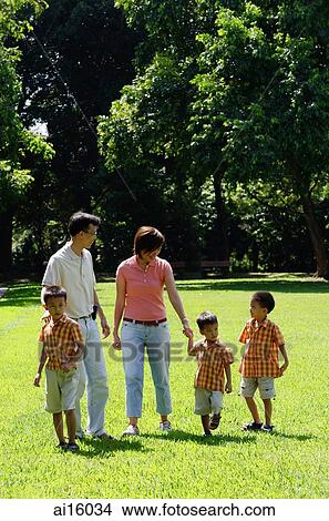 Picture - Family with three boys walking in park. Fotosearch