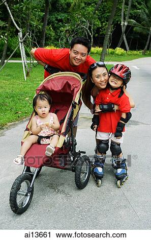 Stock Image - Family with two children at the park looking at camera. Fotosearch
