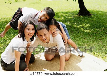 Family with two children, children climbing on father, all looking at camera View Large Photo Image Picture - Family with two children, children climbing on father, all looking at camera. Fotosearch