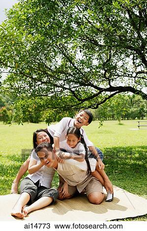 Stock Image - Family with two children, children climbing on father. Fotosearch