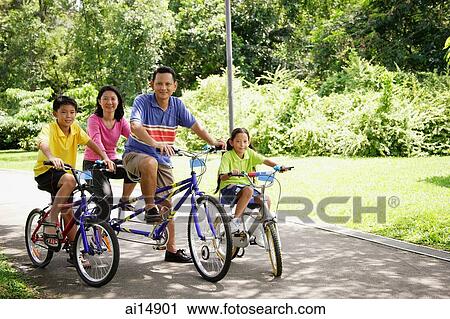 Family with two children, on bicycles, looking at camera View Large Photo Image Stock Image - Family with two children, on bicycles, looking at camera. Fotosearch