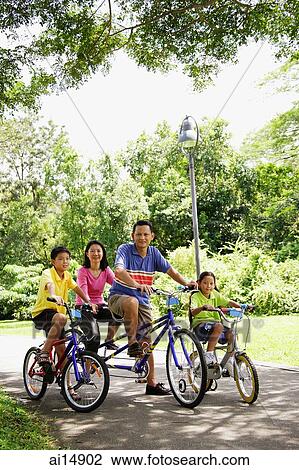 Family with two children, on bicycles, portrait View Large Photo Image Stock Image - Family with two children, on bicycles, portrait. Fotosearch