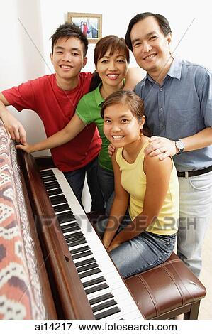 Family with two children, standing around piano, portrait View Large Photo Image Stock Photo - Family with two children, standing around piano, portrait. Fotosearch