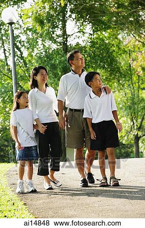 Stock Photo - Family with two children, walking in park. Fotosearch