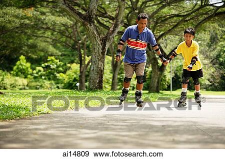 Stock Photo - Father and son in-line skating in park. Fotosearch