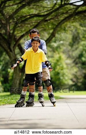 Father and son, in-line skating in park, father holding son from behind View Large Photo Image Stock Image - Father and son, in-line skating in park, father holding son from behind. Fotosearch