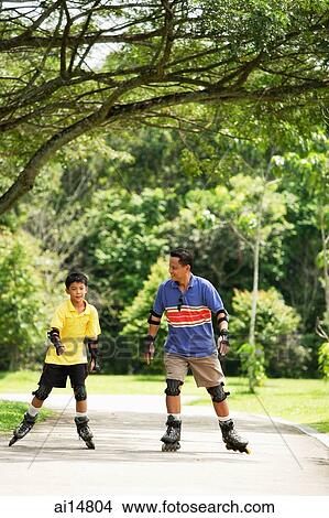 Father and son in park, on roller blades View Large Photo Image Picture - Father and son in park, on roller blades. Fotosearch