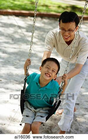 Father and son in playground, father pushing son on swing View Large Photo Image Stock Photograph - Father and son in playground, father pushing son on swing. Fotosearch