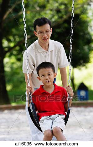 Father and son in playground, father pushing son on swing View Large Photo Image Stock Photography - Father and son in playground, father pushing son on swing. Fotosearch